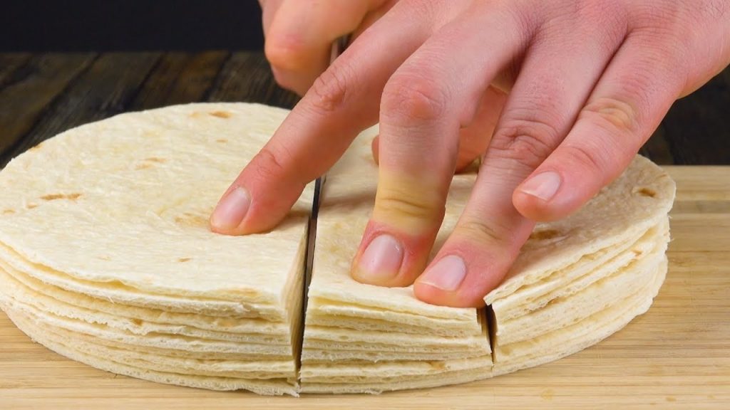 Staple 10 Tortillas aufeinander und schneide sie in 4 Streifen. Dann ab damit in die Kuchenform!